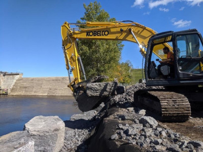 limestone blocks being lines up on bank by use of excavator