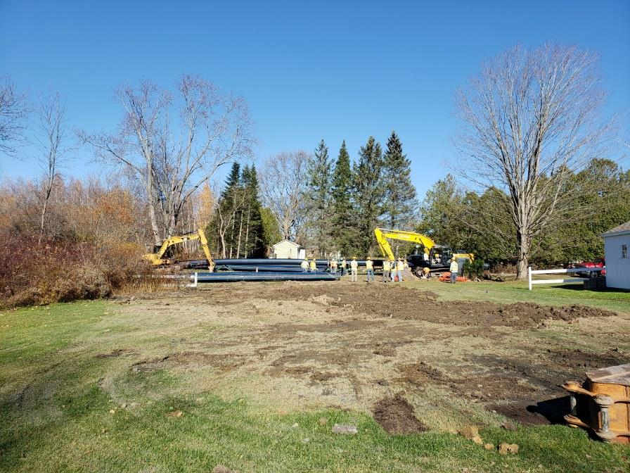 pan-out view of area with pipes, people and equipment