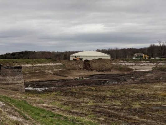 far away shot of tank in background surrounded by muddy field