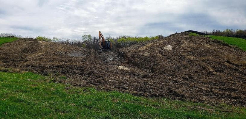 excavator in center of new embankment