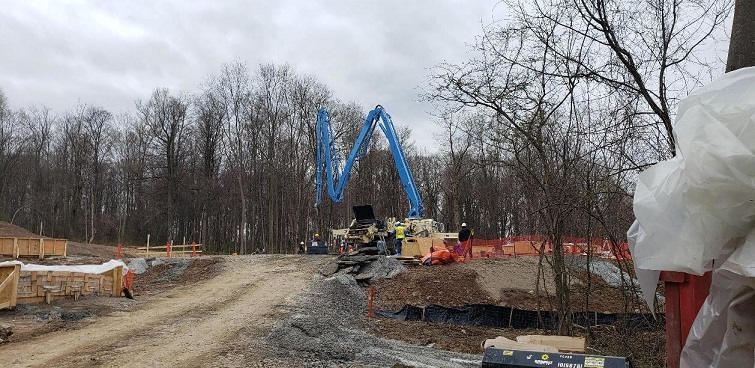 unpaved road woth high-vis fencing and eath moving equipment