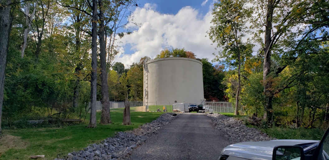 completed tank in background, roadway leading in forground
