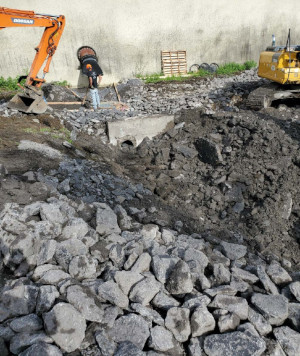 supervisor overseeing backhoe next to tank